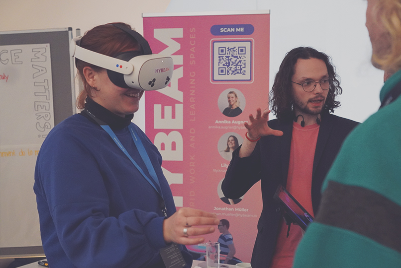 Teilnehmerin nutzt eine VR Brille im Austausch mit einem Experten.