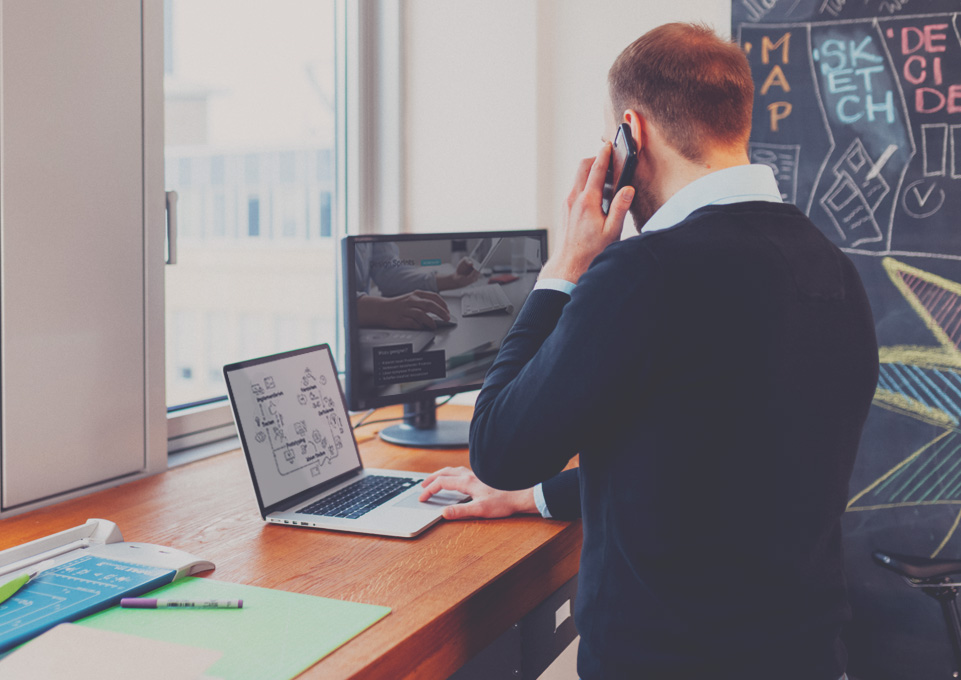 UX-Designer vor laptop am telefon